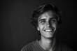 © darshika - Monochrome portrait of young smiling Caucasian man on black background