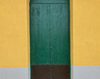 green door to apartment on background of yellow wall
