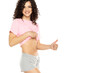 Happy fit young woman showing flat belly on a white background and showing thumbs up