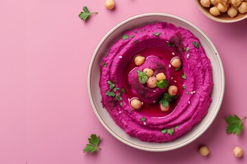 Wall Mural - Whipped beetroot hummus with chickpeas and parsley on a pastel background