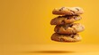 © Jevjenijs - A stack of chocolate chip cookies against a yellow-orange backdrop One cookie is biten