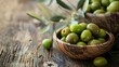 Whole green olives in wooden bowl on vintage wood backdrop with olive tree leaves. Gourmet and organic food photography