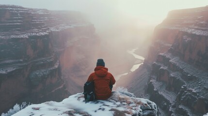 Canvas Print - Hiker sitting in winter in rugged lands with snow.