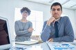 © Mediaphotos - Portrait of two colleagues man and woman working with charts and graphs at office table