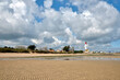 Beach at low tide and lighthouse at Ouistreham with a sky with heavy clouds, a commune in the Calvados department in the Basse-Normandie region in northwestern France.
