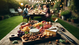 Fototapeta  - A close-up of a charcuterie board filled with an assortment of cheeses, meats, nuts, and fruit, placed on a rustic wooden table in a charming backyard with people in the background.
