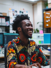 Wall Mural - Smiling african american young man at her workplace, working hard in the office at her desk. Pleasant working atmosphere