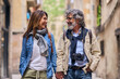Happy mature romantic couple look at each other smiling on tourist street. Pensioners enjoying leisure time together on holidays. Middle-aged husband and wife in love holding hands outdoor
