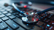 A close-up of a stethoscope lying on a computer keyboard, symbolizing healthcare and technology.