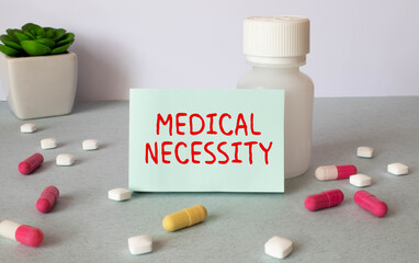 Medical necessity text is written by the hand of a jerk on a white sheet of paper on a table