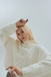 Cute woman in a white sweater posing on a light background, Korean-style photos