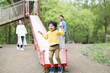 新緑の公園の滑り台で遊ぶアジア人（日本人）の親子 3人家族　パパ(父親）の子育てや育児の休日のイメージ	ジャンプする子供
