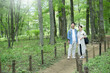 Couple traveling in spring and summer when fresh greenery and green are beautiful Image of sightseeing, walking, and trekking in summer resort areas, etc.