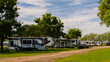 Large Rv trailers parked at campsite on grass