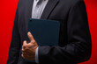 Close up hands of businessman using digital tablet device isolated on red background.