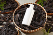 Top view photo at a blank label bottle flat lay on a bamboo basket of black locust fruit. Mockup for advertise natural cosmetic or beauty product made from locust