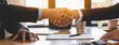 close-up view hands of agent and client shaking hands after signed contract buy new apartment.