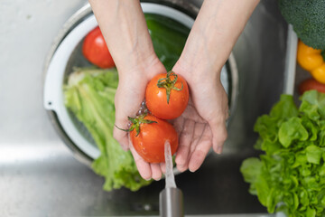 Wall Mural - people washing raw vegetables at sink in the kitchen prepare ingredient for cooking