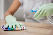 Cleaning, bottle and person spray surface for disinfecting furniture for hygiene, dust and housework. Housekeeper or maid, detergent and cloth for wiping, bacteria and germs in apartment house