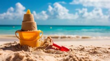 A Detailed Sand Fortress With A Yellow Bucket And Red Shovel Against The Serene Blue Sea Embodying The Joy Of Beach Holidays
