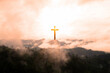 Cross on the mountain with misty sunrise background. Christian concept.