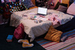 High angle view of part of teenagers bedroom interior with laptop, clothes and notebooks on bed, no people shot