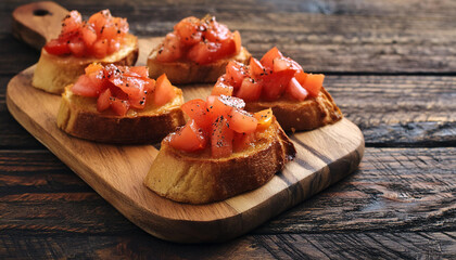 Wall Mural - A rustic tomato bruschetta on a wooden cutting board.