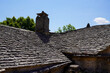 roof tiles stone grey from old farm house medieval building with chimney gray stones background