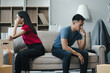 Unhappy young couple sitting apart, having problems in relationship, thinking of breaking up or divorce, upset, family lovers, man and woman avoid talking in relationship problems.