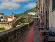 Narrow cobblestone walkway and old bridge in Dolceacqua, Italy.