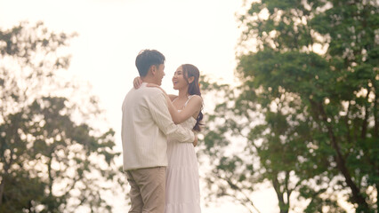 Sweet lovers arm around shoulder hug neck face to face talking at outdoor nature. Trust true love smile happy asia people in casual bride groom white dress begin family life just married young couples