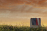Fototapeta Góry - American flag laying on gravestone at peaceful flower meadow to remember the memorial day. 3D Rendering