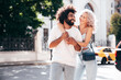 © halayalex - Smiling beautiful woman and her handsome boyfriend. Woman in casual summer jeans clothes. Happy cheerful family. Female having fun. Sexy couple posing in the street at sunny day. Embracing each other