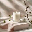 A lit candle with cherry blossoms on a pink background