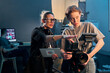© Mediaphotos - Waist up portrait of female director giving instructions working in video production and operating cameras copy space
