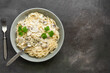 Spaghetti pasta with creamy mushroom sauce on a dark grunge background. Italian traditional dish. Top view, copy space
