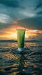 A green tube of sunscreen sits in the ocean at sunset.