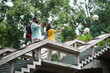 © pressmaster - Young couple standing on big staircase construction during sightseeing excursion and taking pictures of natural and urban scenes