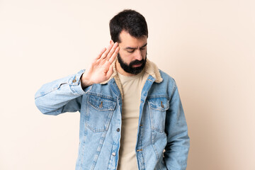 Wall Mural - Caucasian man with beard over isolated background making stop gesture and disappointed