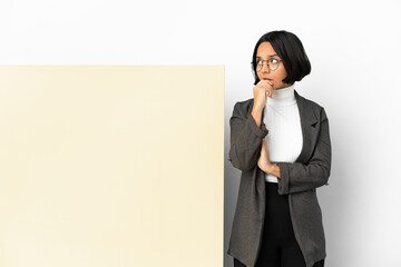 Wall Mural - Young business mixed race woman with with a big banner over isolated background having doubts and with confuse face expression
