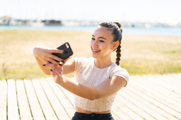 Wall Mural - Young moroccan girl  at outdoors making a selfie with mobile phone