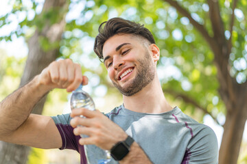 Wall Mural - Sport man with a bottle of water at outdoors