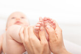Fototapeta  - Physiotherapist performing massage on infant's feet