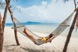 Traveler asian woman relax and travel in hammock on summer beach at Koh Rap Samui in Surat Thani Thailand
