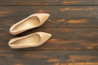 Women's heeled shoes on dark wooden background..