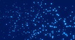 Image of multiple blue spots of light floating on a dark blue background