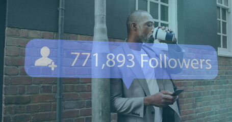 Wall Mural - Image of numbers and followers text on banner over man having coffee and using smartphone