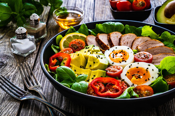 Canvas Print - Tasty salad - roasted veal loin, avocado, boiled eggs and fresh vegetables on wooden table
