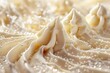 Close-up of creamy vanilla frosting peaks adorned with tiny sugar beads, showcasing texture and soft color nuances.