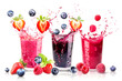 Three drinks with strawberry, blueberry and raspberry in splashing fresh juice isolated on white background.